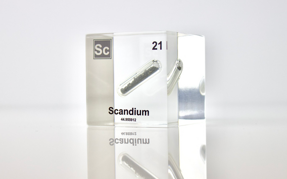 Clear acrylic cube displaying a Scandium element (Atomic Number 21) embedded within, offering a scientific presentation for collectors and science enthusiasts.