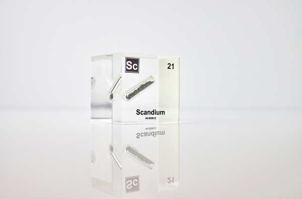 Clear acrylic cube displaying a Scandium element (Atomic Number 21) embedded within, offering a scientific presentation for collectors and science enthusiasts.