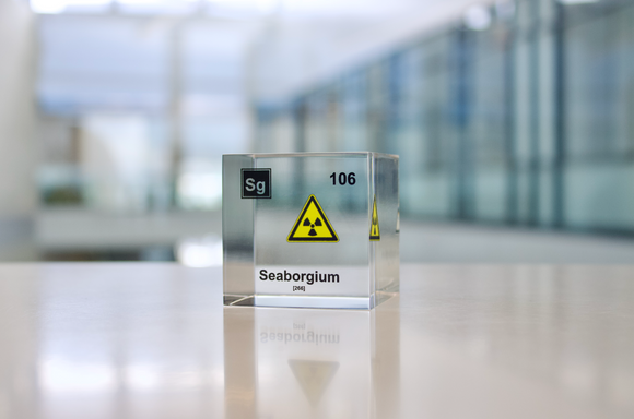 Clear acrylic cube displaying a Seaborgium element (Atomic Number 106) embedded within, offering a scientific presentation for collectors and science enthusiasts.