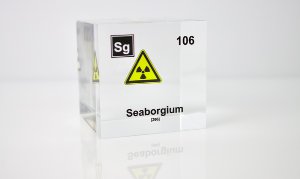 Clear acrylic cube displaying a Seaborgium element (Atomic Number 106) embedded within, offering a scientific presentation for collectors and science enthusiasts.