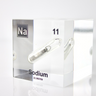 Clear acrylic cube containing a Sodium ampule, marked with its atomic number 11. Perfect for showcasing in educational environments, scientific collections, or as a unique decorative element.