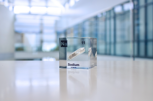 Clear acrylic cube containing a Sodium ampule, marked with its atomic number 11. Perfect for showcasing in educational environments, scientific collections, or as a unique decorative element.