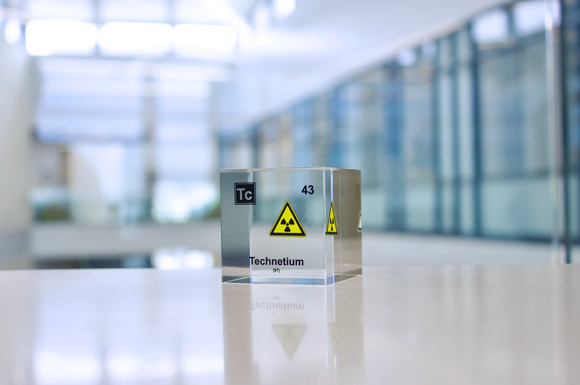 Clear acrylic cube displaying a Technetium element (Atomic Number 43) embedded within, offering a scientific presentation for collectors and science enthusiasts.