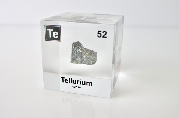 Clear acrylic cube displaying a Tellurium element (Atomic Number 52) embedded within, offering a scientific presentation for collectors and science enthusiasts.