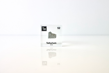 Clear acrylic cube displaying a Tellurium element (Atomic Number 52) embedded within, offering a scientific presentation for collectors and science enthusiasts.