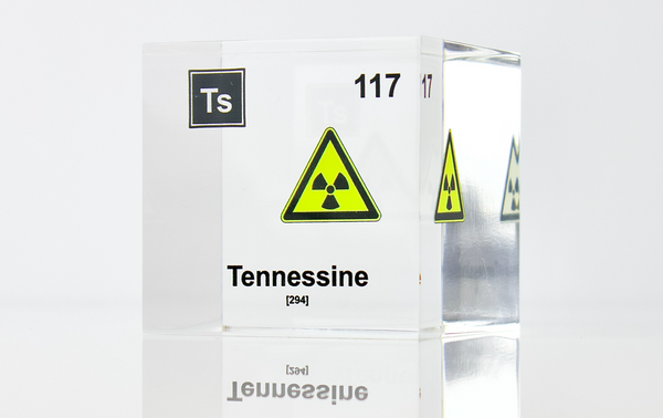 Clear acrylic cube displaying a Tennessine element (Atomic Number 117) embedded within, offering a scientific presentation for collectors and science enthusiasts.