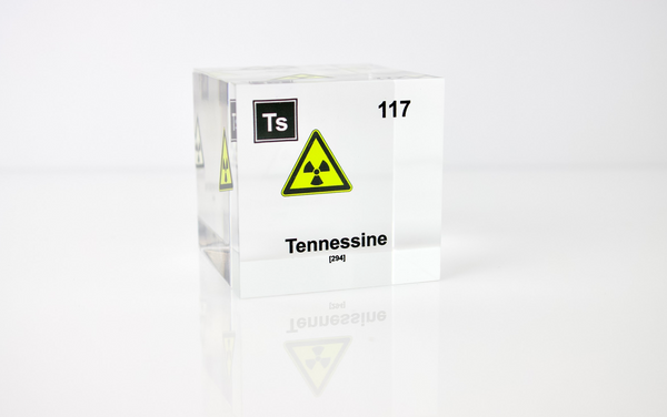 Clear acrylic cube displaying a Tennessine element (Atomic Number 117) embedded within, offering a scientific presentation for collectors and science enthusiasts.