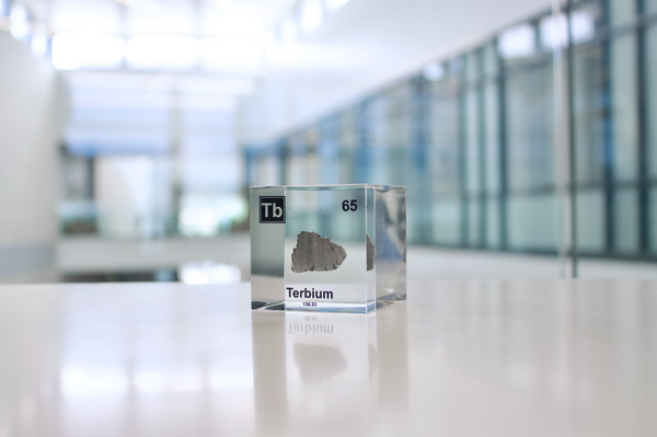 Clear acrylic cube displaying a Terbium element (Atomic Number 65) embedded within, offering a scientific presentation for collectors and science enthusiasts.