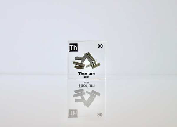 Clear acrylic cube displaying a Thorium element (Atomic Number 90) embedded within, offering a scientific presentation for collectors and science enthusiasts.