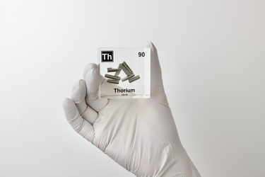 Clear acrylic cube displaying a Thorium element (Atomic Number 90) embedded within, offering a scientific presentation for collectors and science enthusiasts.