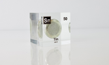 Clear acrylic cube displaying a Tin element (Atomic Number 50) embedded within, offering a scientific presentation for collectors and science enthusiasts.