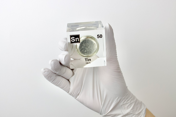 Clear acrylic cube displaying a Tin element (Atomic Number 50) embedded within, offering a scientific presentation for collectors and science enthusiasts.