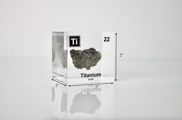 Clear acrylic cube displaying a Titanium element (Atomic Number 22) embedded within, offering a scientific presentation for collectors and science enthusiasts.