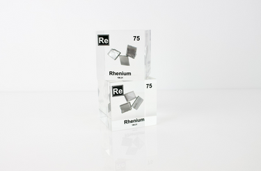 Rhenium element in a clear acrylic cube, featuring its name, atomic number, and properties as shown on the periodic table. A sleek and educational display for collectors and enthusiasts.