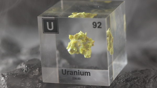 Clear uranium element cube from periodic table with real elements.