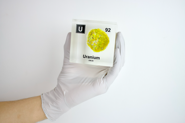 Clear acrylic cube showcasing a Uranium element (Atomic Number 92) embedded within, offering a scientific display for collectors and science enthusiasts.