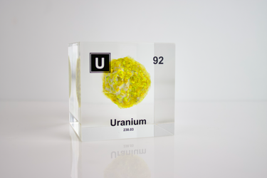 Clear acrylic cube showcasing a Uranium element (Atomic Number 92) embedded within, offering a scientific display for collectors and science enthusiasts.