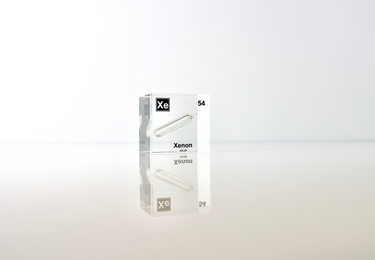 Clear acrylic cube displaying a Xenon element (Atomic Number 54) embedded within, offering a scientific presentation for collectors and science enthusiasts.