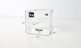 Clear acrylic cube displaying a Xenon element (Atomic Number 54) embedded within, offering a scientific presentation for collectors and science enthusiasts.