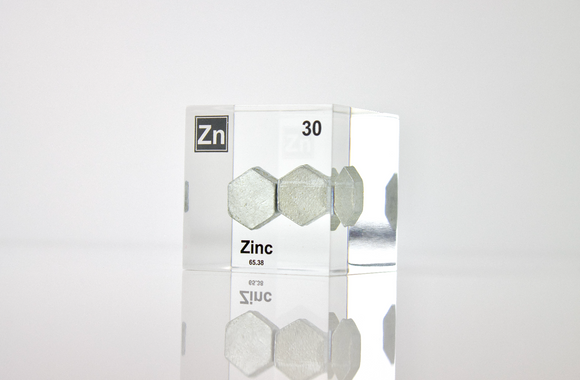 Zinc element encased in a clear acrylic cube, featuring its name, atomic number 30, and properties as displayed on the periodic table. Ideal for educational and collector use.