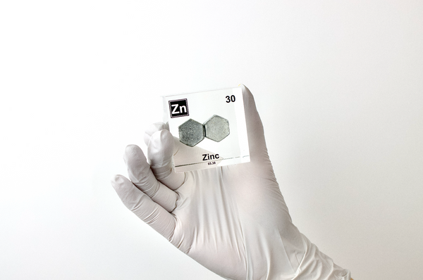 Zinc element encased in a clear acrylic cube, featuring its name, atomic number 30, and properties as displayed on the periodic table. Ideal for educational and collector use.