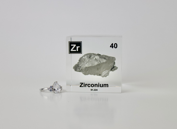 Clear acrylic cube displaying a Zirconium element (Atomic Number 40) embedded within, offering a scientific presentation for collectors and science enthusiasts.