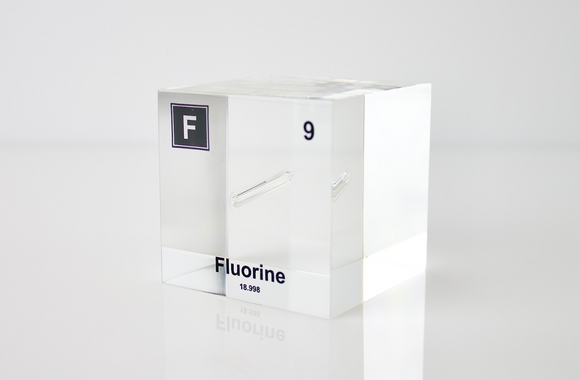 Clear acrylic cube encasing a Fluorine ampule with its atomic number 9. Ideal for display in educational settings, scientific collections, or as a decorative piece.