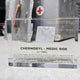 Clear acrylic display case featuring a historical fragment of a Chernobyl medic box, offering an educational presentation for collectors and those interested in nuclear history.